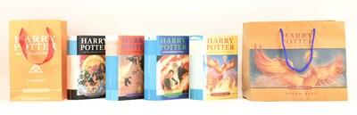 Lot 26 - ROWLING, J. K. FOUR HARRY POTTER FIRST EDITIONS & TWO ORIGINAL RELEASE THEMED GILT BAGS