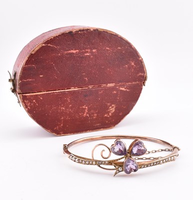 Lot 54 - EARLY 20TH CENTURY 9CT GOLD AMETHYST & PEARL HINGED BANGLE