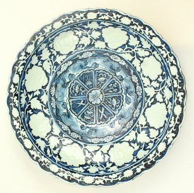 Lot 111 - A LARGE YUAN STYLE BLUE AND WHITE PORCELAIN BARDED CHARGER 元或以后 青花牡丹莲花纹花口盘