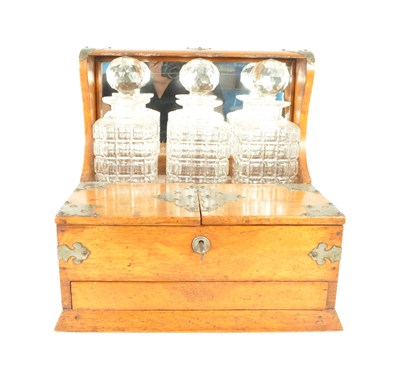 Lot 325 - ARTS AND CRAFTS STYLE TANTALUS WITH THREE CUT CRYSTAL DECANTERS