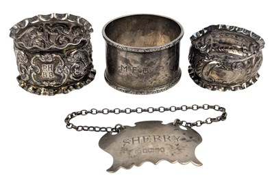 Lot 57 - THREE HALLMARKED SILVER NAPKIN RINGS & A SILVER SHERRY BOTTLE TAG